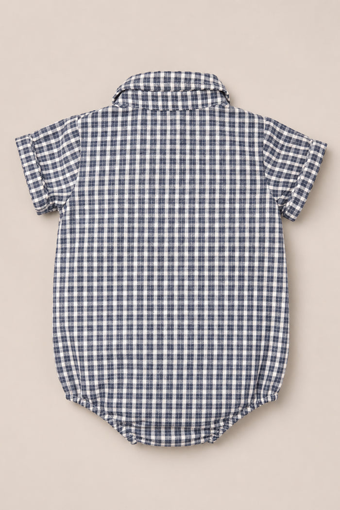 The Ivy City Co Baby Lucas Romper in Prussian Blue Plaid is a blue and white checkered cotton romper with short sleeves and a collar neckline, displayed flat with the back facing up.