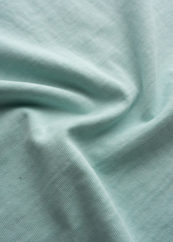 Close-up of men’s 10.25 oz heavyweight jersey cotton t-shirt in Aqua, detailing fabric, durable construction and soft feel