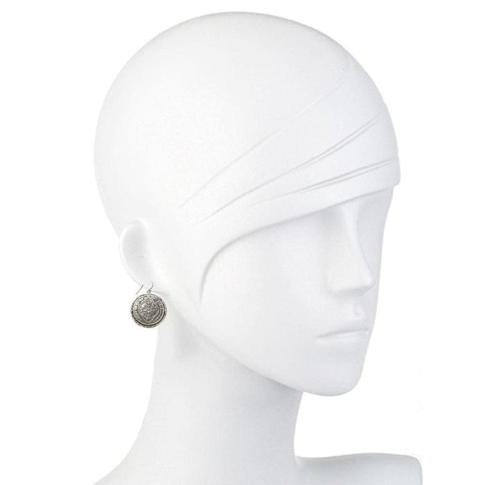 Silver hook earrings with ornate, circular design on a mannequin.