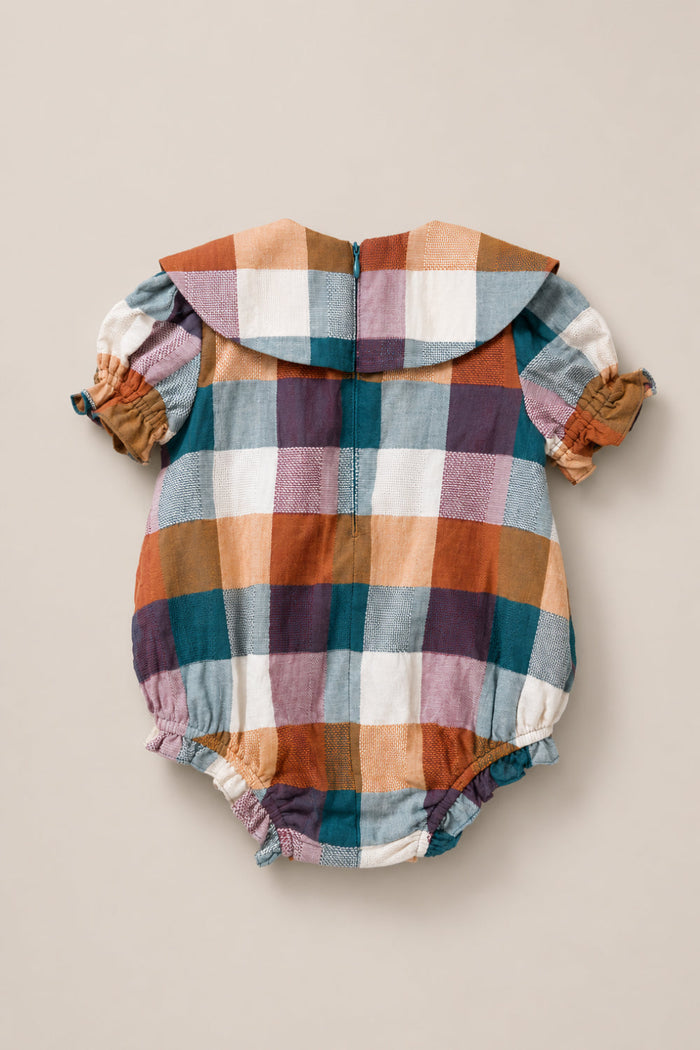 The Ivy City Co Baby Alice Romper in Maize Gingham showcases an eye-catching large gingham pattern in orange, blue, brown, white, and purple tones. This charming cotton romper is crafted with short puff sleeves, an oversized collar, and elastic leg openings for easy comfort. The soft, lightweight fabric ensures gentle wear for your little one.