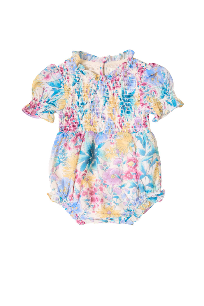 The Ivy City Co Baby Cordelia Romper in Pretty Plumeria features pastel pink, yellow, blue, and green florals with short puffed sleeves and a ruffled collar, shown on a white background.
