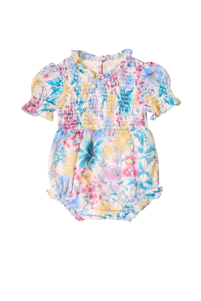 The Baby Cordelia Romper in Pretty Plumeria from Ivy City Co features short puff sleeves, a ruffled collar, and a vibrant floral pattern in blue, pink, and yellow—perfectly capturing the charm of a spring romper. This adorable piece is showcased against a white background.