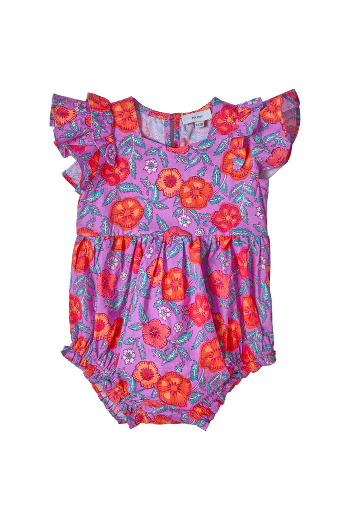The Ivy City Co Baby Hattie Romper in Thistle Flower Poppy Woodblock features ruffled sleeves, a smocked bodice, and bright red, orange, and purple floral prints on lavender with elastic leg openings and a gathered waist for comfort.