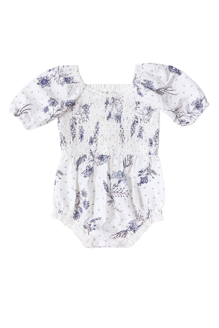 The Ivy City Co Baby Roselyn Romper in Blue Enchanted Floral features short puffed sleeves, an elasticized neckline and waist, making it a charming pick for little ones and perfect for a Mom & Me set.