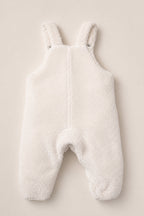 The Baby Siena Onesie in Ivory & Midnight Garden by Ivy City Co is a white, fuzzy sherpa romper with shoulder straps and convenient snap closures, shown laid flat on a neutral background. This sleeveless design features soft, warm fabric to keep babies cozy during chilly weather.