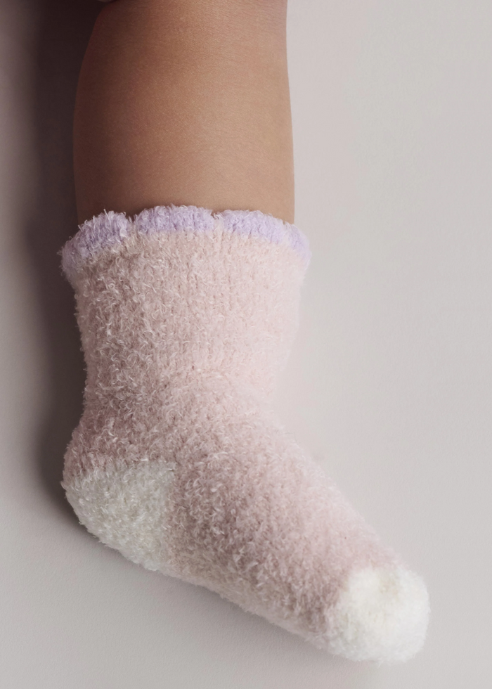 A baby wearing a light pink sock