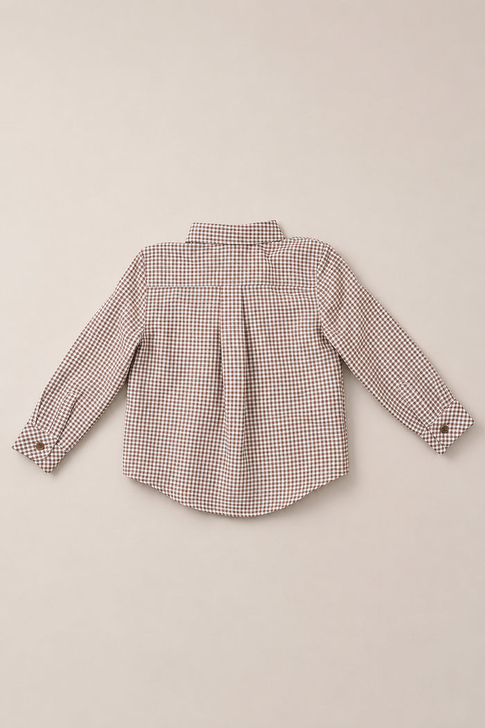 The Boys John Shirt in Brown Gingham by Ivy City Co is a long-sleeved woven cotton shirt for boys, shown from the back against a light beige background and featuring a small brown and white checkered pattern.