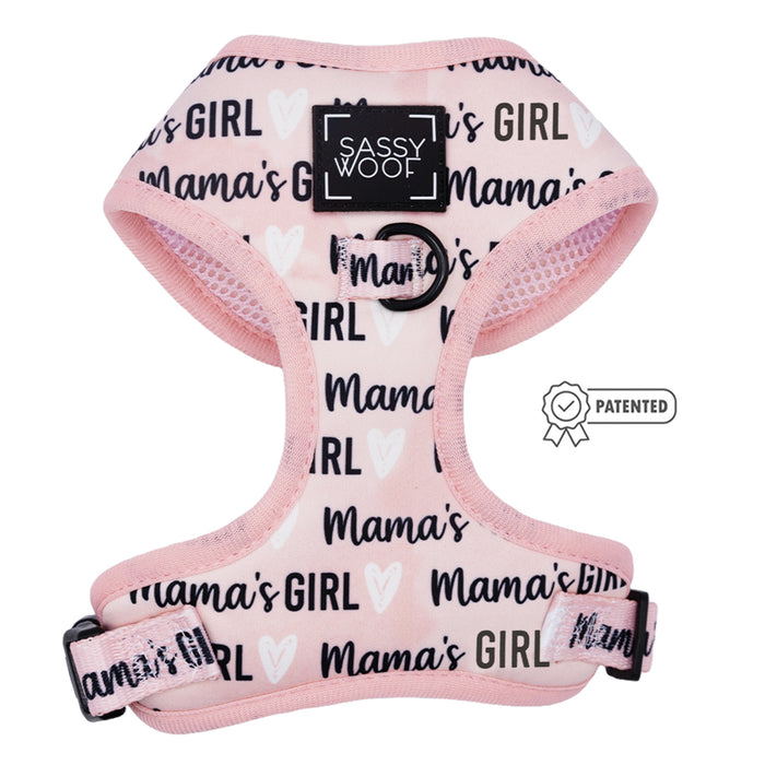 The Dog Adjustable Harness - Mama's Girl by Sassy Woof is pink, features repeated black and white "Mama's Girl" text, a Sassy Woof logo on the chest, and a patented badge on the right side.