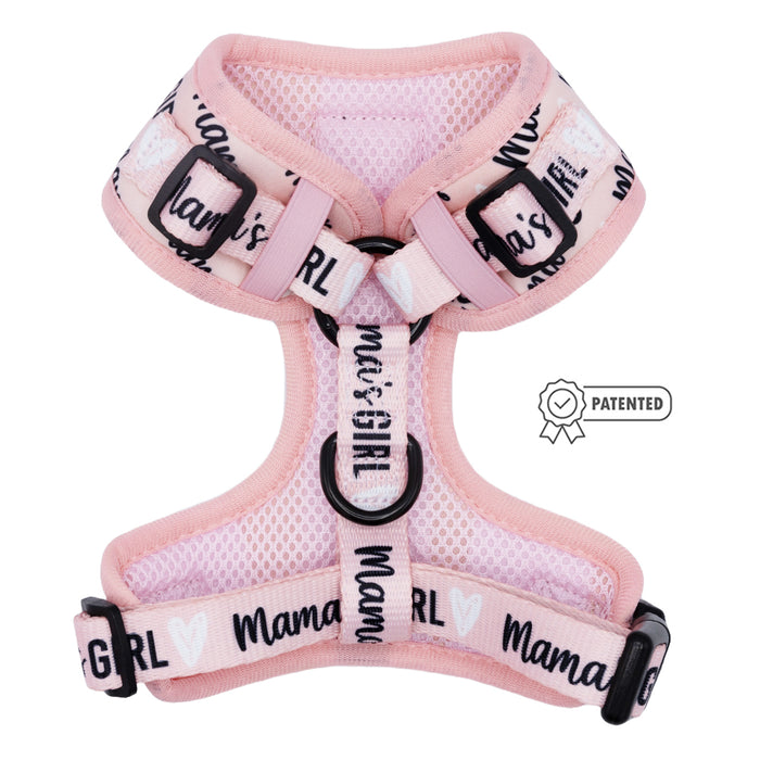 The Sassy Woof Dog Adjustable Harness - Mama's Girl is a pink mesh, no-pull harness for dogs with black buckles, “Mama’s Girl” print, a front metal ring, adjustable fit, and a patented icon on the side.