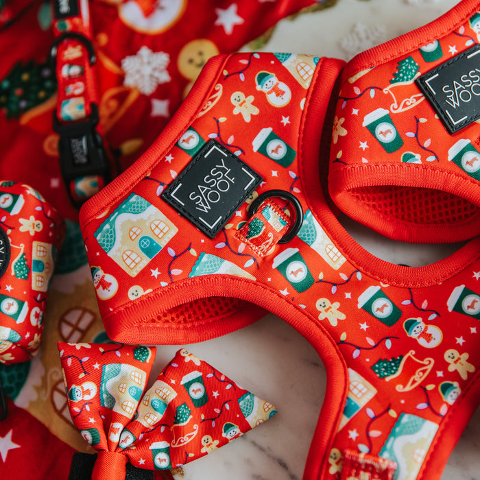 Close-up of Sassy Woof’s Dog Adjustable Harness - Sleigh Baby Sleigh, featuring bright red festive holiday patterns, a black Sassy Woof label, and matching bow tie and leash—perfect Christmas pet accessories!.