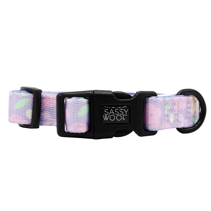 The Sassy Woof Dog Collar - Fleur de Sass features a pastel purple and pink abstract pattern, an adjustable neoprene design, black plastic buckle, sturdy metal ring, and is perfect for the Puppy Growth Pawtection Plan.