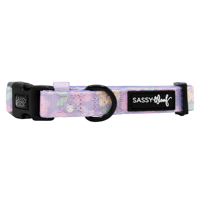 The Sassy Woof Dog Collar - Fleur de Sass is a pastel purple and pink adjustable collar with a black buckle, sturdy metal ring, and label. Made from soft neoprene, it offers comfort and style for your pup.