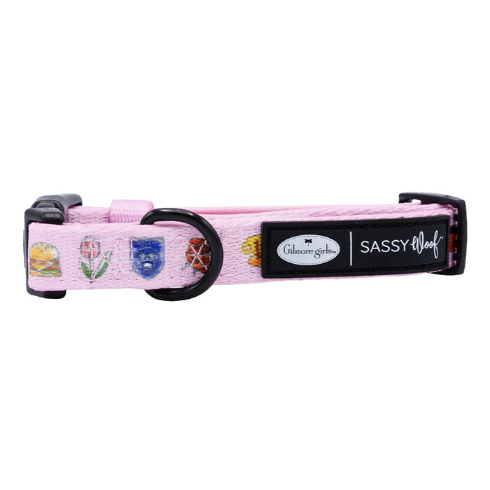 The Dog Collar - Gilmore Girls™ by Sassy Woof is a pink adjustable neoprene collar with burger, coffee cup, and book icons. Part of the Stars Hollow collection, it features branded labels and sleek black hardware.
