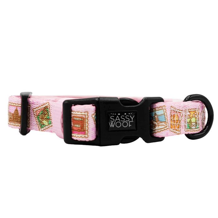 The Sassy Woof Dog Collar - Out of Office features a pink adjustable fit, black plastic buckle, metal leash ring, and colorful postage stamp designs. Perfect for pups in the Puppy Growth Pawtection Plan.