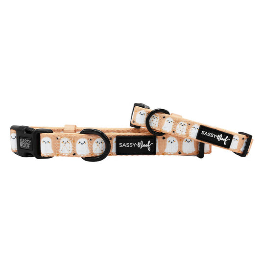 Two Sassy Woof "Squad Ghouls" beige adjustable dog collars with black hardware and a white ghost pattern appear side by side on a white background—perfect for spooky style or as Halloween dog accessories.
