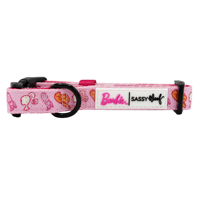 The Dog Collar - Western Barbie™ by Sassy Woof features pink styling with Barbie faces, hearts, and logo details plus black plastic hardware—a must-have collar for fashionable pups.