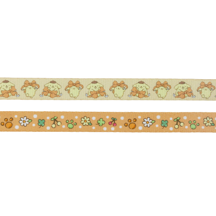 This Dog Collar Three Piece Bundle - Pompompurin™ by Sassy Woof includes two stylish decorative tapes: one showcases a repeating pattern of an adorable cartoon dog in a brown hat—echoing the beloved Sanrio character Pompompurin™, ideal for fans of cute dog accessories—while the other features playful orange, green, and white flowers, paw prints, and dots set against a vibrant orange background.