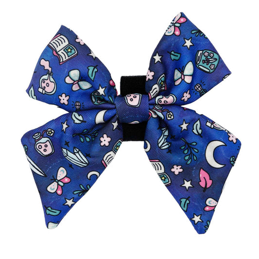 The "Dog Sailor Bow - Spellbound" by Sassy Woof features pastel moons, stars, butterflies, and potion bottles—an enchanting accessory for witchy pups seeking a mystical style.