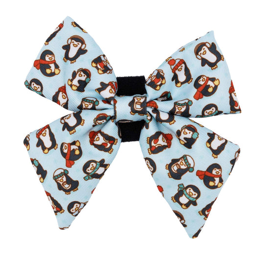 The Sassy Woof Dog Sailor Bow - Winter Waddleland features a large, light blue design with cute cartoon penguins in red scarves, hats, and earmuffs—ideal for fans of adorable winter dog accessories.