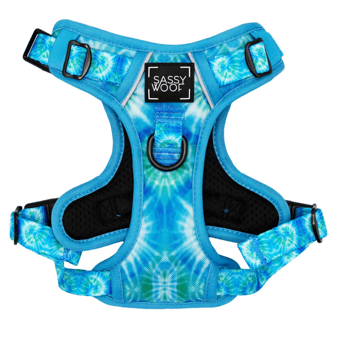 The Sassy Woof Dog Step-in Harness - Tropical Tides features a blue and white tie-dye design, adjustable straps, black buckles, a front D-ring, and a chest label for comfort and security.
