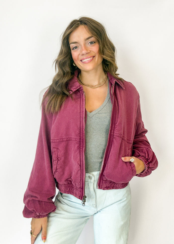 A woman wearing a dusty rose jacket over