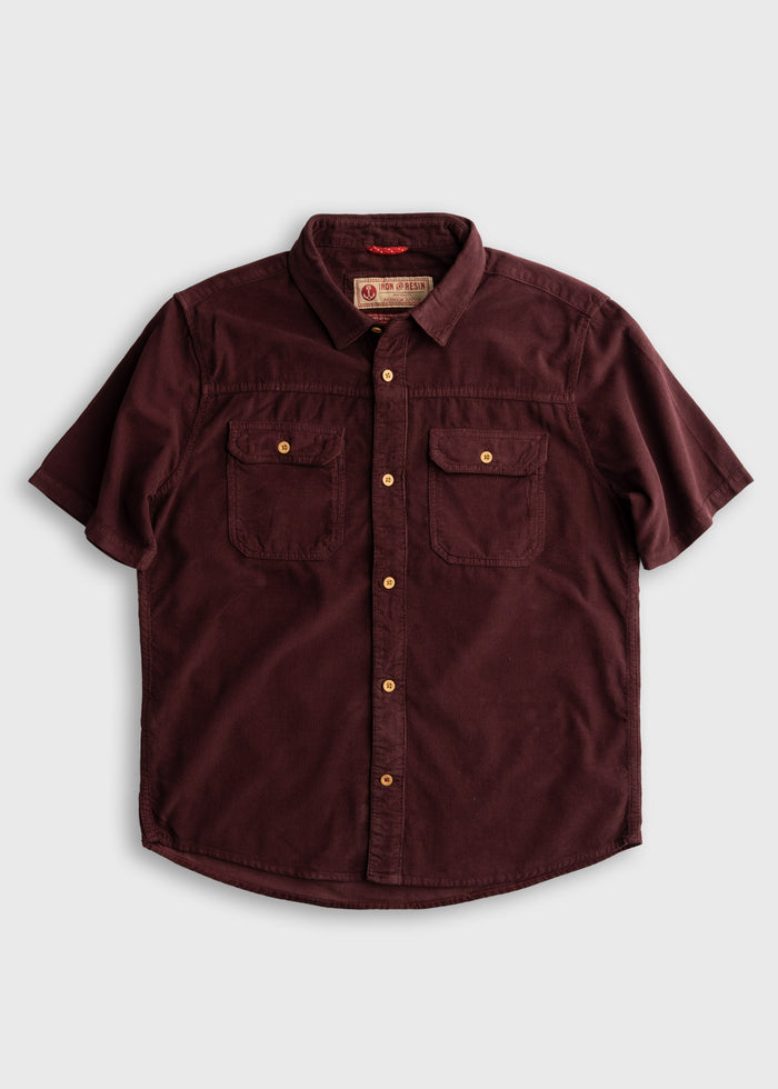 Maroon short-sleeve button-up shirt with two chest pockets and wooden buttons, displayed on a light gray background.