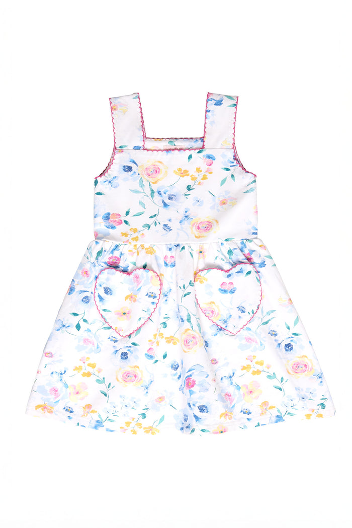 The Ivy City Co Mini Rue Play Dress in Blue Bouquet is a sleeveless girls’ dress with a colorful floral print, pink-trimmed straps, and two heart-shaped skirt pockets, designed in the brand’s playful signature style.