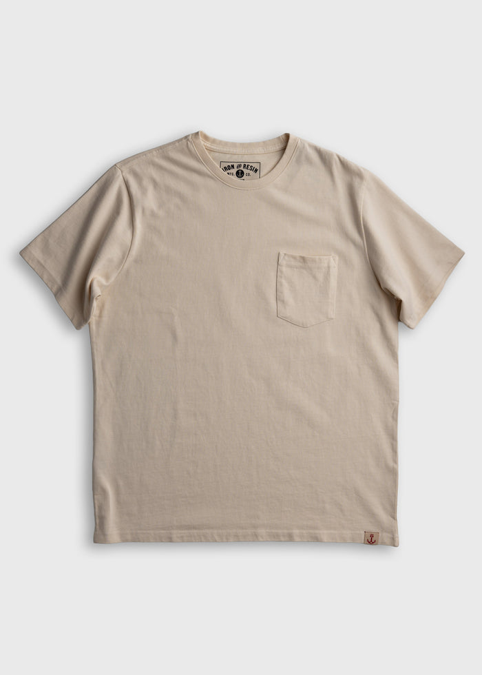 Beige T-shirt with a chest pocket, featuring a subtle logo on the collar and a small anchor tag at the bottom hem.