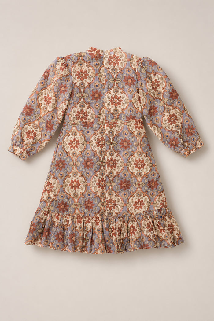 Introducing the Ivy City Co Teen Draper Dress in Golden Hour Tesserae—a long-sleeved, knee-length dress with elegant balloon sleeves and a ruffled hem. Featuring a vintage-inspired floral and geometric pattern in warm shades of brown, red, and blue on a light background, this dress is perfect for effortless fall style.