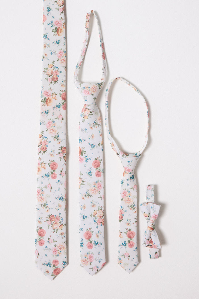 Four white ties and bow ties by Ivy City Co, adorned with the charming Countryside Peony Blossom design, are arranged vertically against a white background. These coordinated accessories are available in styles for adults, children, and infants—perfect for creating a matching family look.