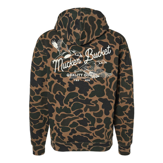 The Youth Wood Ducks Premium Duck Camo Hoodie by Mucker Bucket features a relaxed fit camo design with crossed duck calls, "Mucker Bucket," and "Quality Goods TRD MRK" in white on the back—perfect for young hunters.